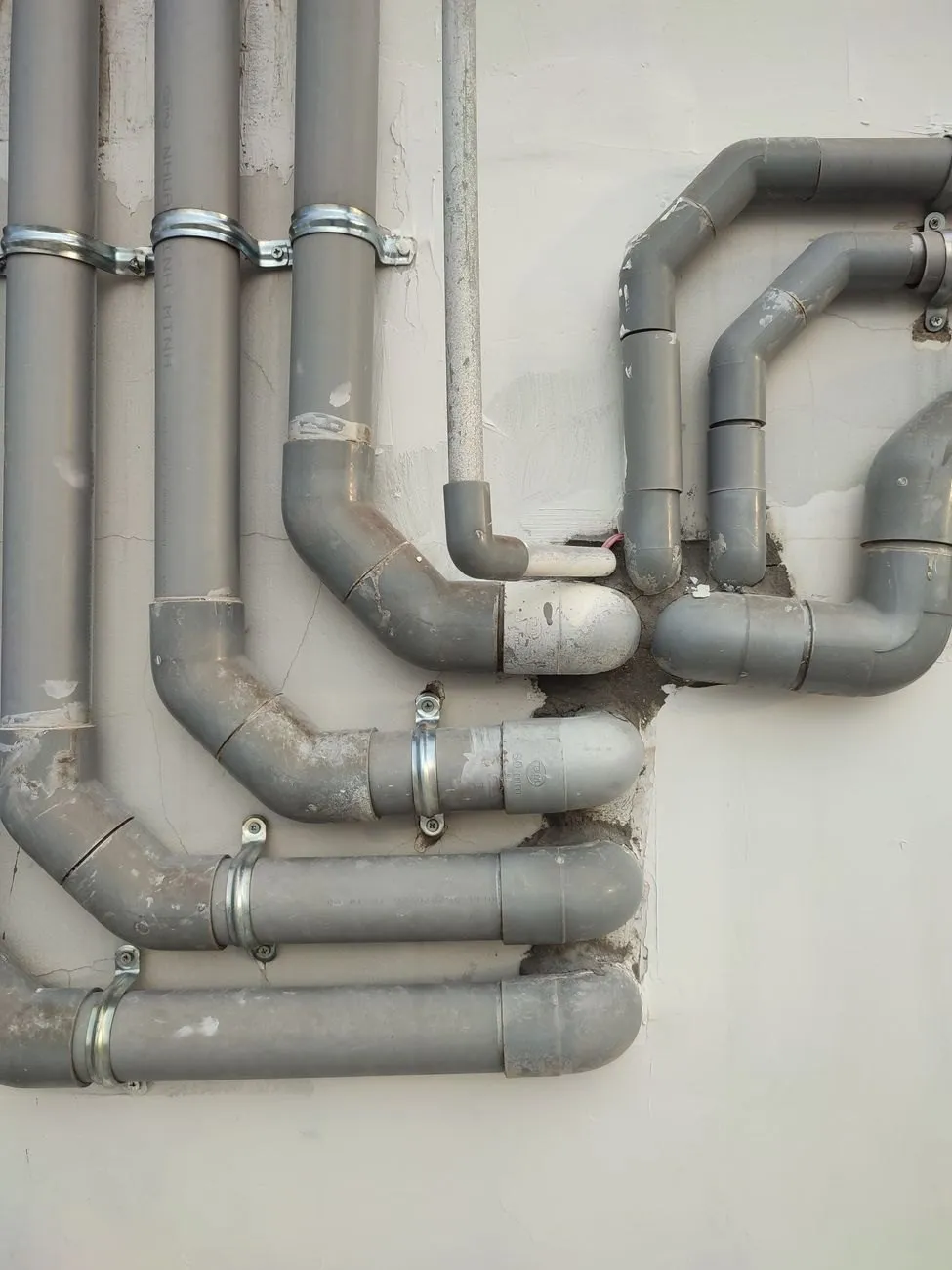 Grey plastic soil and waste pipes on an outside wall